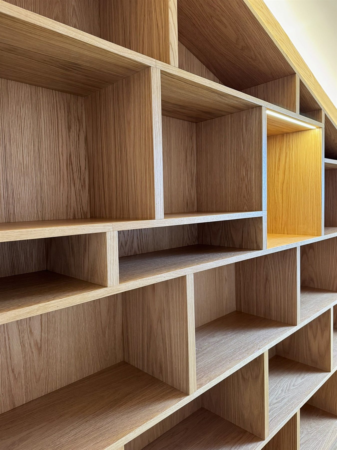 Stepped oak shelving following the angle of the roof